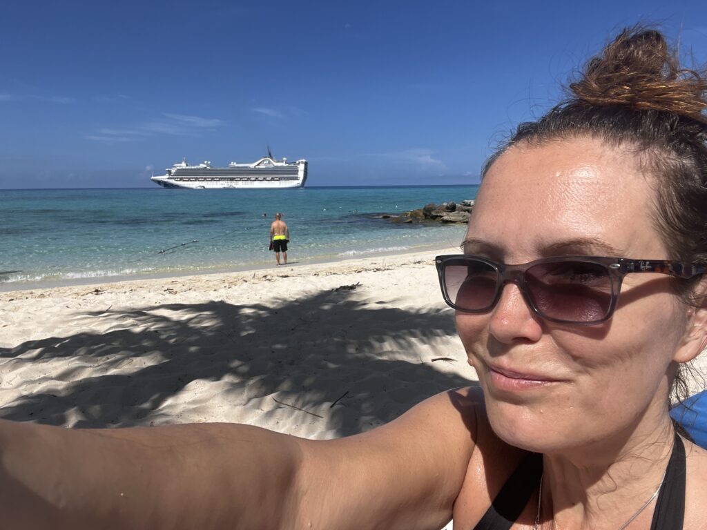 Picture of site author on a beach with the Caribbean princess cruise ship in the background