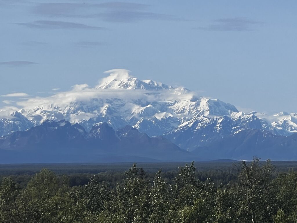 The Peak of Mount Denali showing through the mountain tops